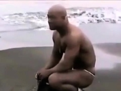 Asian bodybuilder barely covered at the beach