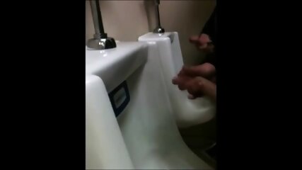 two slim dicks getting wanked at the urinals