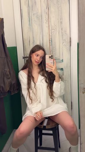 Blonde woman in white dress sitting on stool
