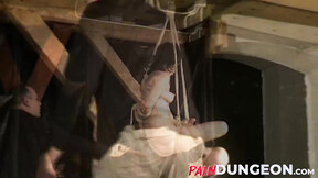 Gagged brunette is spanked by master in dungeon play