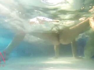 Elegant and supple chick, swimming underwater in the outdoor swimming pool. three two