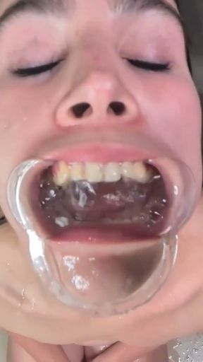 Cheap whore gets her mouth filled with piss using a lip retractor and swallowing it.   Clip 1