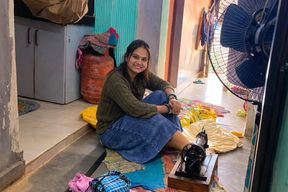 Indian wife sewing on the machine but she has other thoughts too.