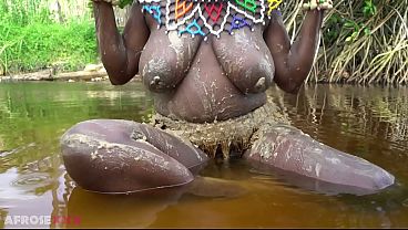 Busty African girlfriend teasing naked in a river outdoor