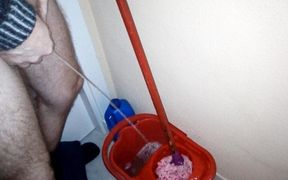 John is taking a piss into the cleaning bucket