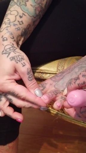 Tattooed blonde lady paints her toenails