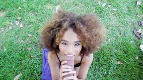 Curly haired teenie with beautiful smile sucks hard pecker outdoors