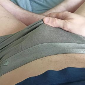 The guy strokes his dick through gray panties