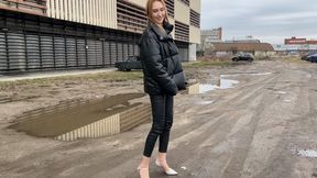 girl walks along a muddy road and gets her shoes and feet dirty