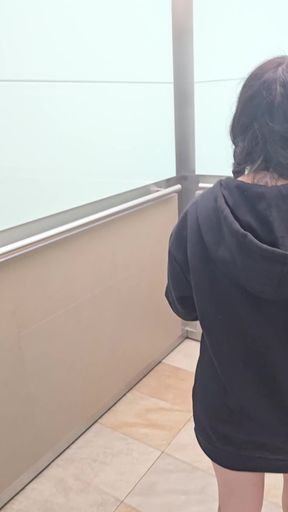 Woman in black hoodie walking through bathroom