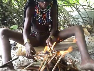 Pretty tribe angel making traditional jewelery next to a firecamp