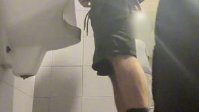 2 boys in sneakers having fun at public toilets  urinal