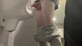2 boys in sneakers having fun at public toilets  urinal