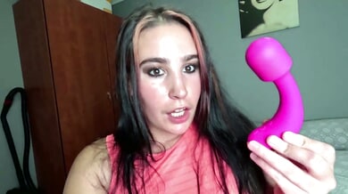 Curvy woman with black-pink hair explores her body with a pink vibrator in bed