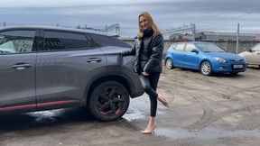 girl in high-heeled shoes loves to listen to the sounds of the engine and play with her feet with the car