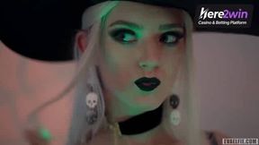 A towheaded woman in a witch hat and black with cum