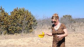 Naughty Nora Blowing A Big Yellow Balloon in the Hot Sun