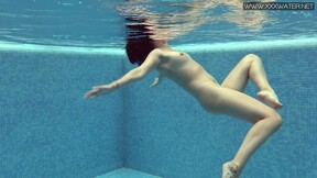 Charming petite teen wearing charming clothes underwater