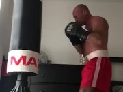 working the bag in red boxing trunks