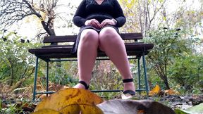 BBW pisses through her panties with her legs spread wide while sitting on a bench.