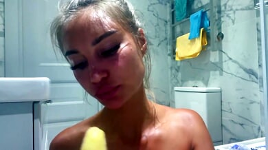 Monika Fox teases with a banana on her chest in a marble bathroom