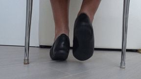 Play of shoes and bare feet under the chair d