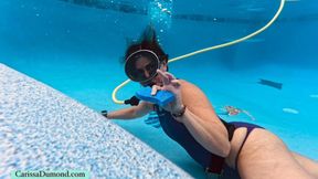 Carissa uses scuba while cleaning the pool in a purple Leohex one-piece suit