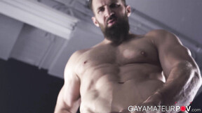 Bushy hunk Chuck Conrad works his fat cock with his two hands after flexing