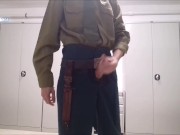 Russian soldier in a Soviet-era uniform masturbates his cock in the barracks in public