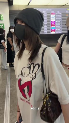 Woman in white hoodie and black beanie walking through airport