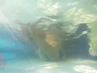 Elegant and supple sweetheart, swimming underwater in the outdoor swimming pool. three two