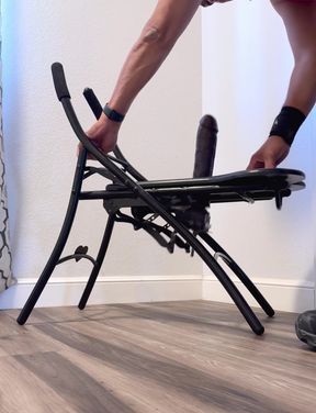 Athletic blond amateur assembles folding chair while sitting solo