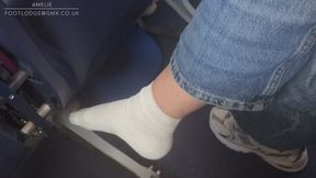 Amelie removes she sneakers on the aircraft