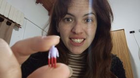 A giantess using her teeth on a miniature man