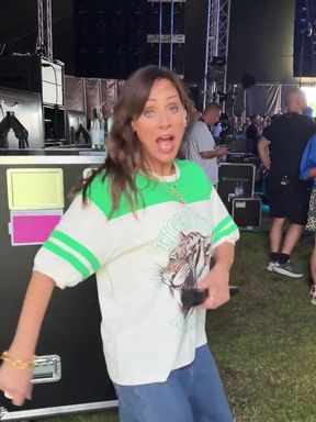 Woman in colorful shirt and jeans on stage