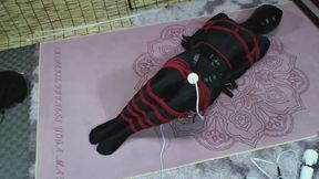 A girl in black stockings struggles tightly bound