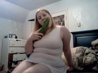 Delightful blonde babe with a big cucumber tries to eat it