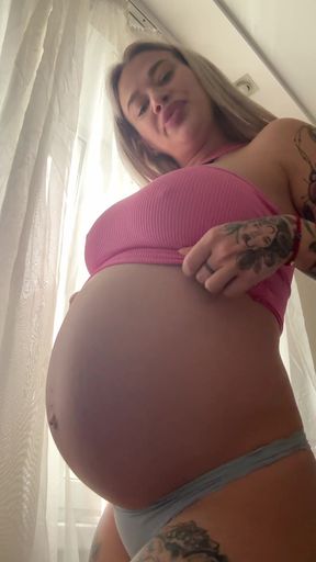 Pregnant belly accentuates big natural tits