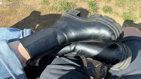 Guy massages Amelie’s feet and boots in the park