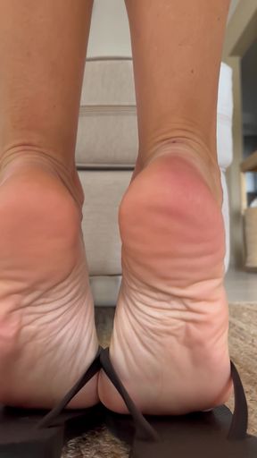 Flirty teen dangles her flip-flops in a playful solo dance