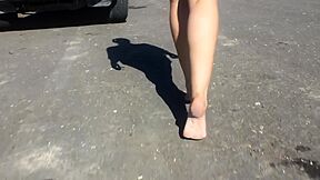 Woman In Short Shorts Walks Around Barefoot Outside On The Pavement