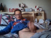 Skinny teen strokes his cock while lying down on a bed