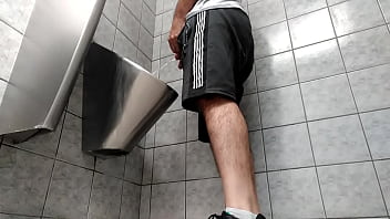 A busy guy with an uncut dick peeing in a public toilet