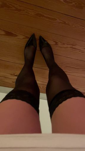 Seductive woman in nylon stockings and high heels teases her lover