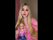 Sweet blonde beauty in pink teasing with her doll