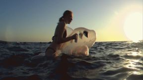 Alla swims astride a transparent rare inflatable whale on the sea!!!