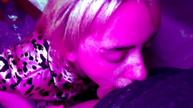 Amateur chokes deep on a large cock under purple lights