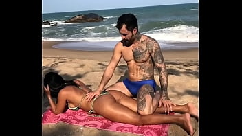 em um dia de Sol em Caraguatatuba no litoral norte de S&atilde_o Paulo Brasil Allan Guerra Gomes Passa Bronzeador na morena deliciosa Dana Bueno