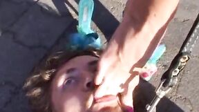 Leashed slave licking mistresses bare feet after a pony play outdoors