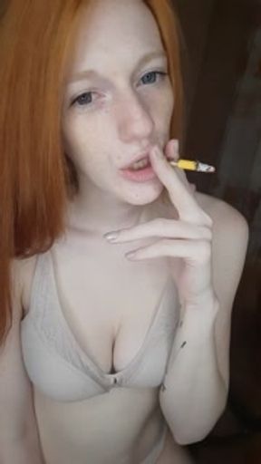 redhead girl smokes a cigarette